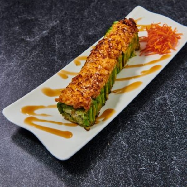 El Sushi Loco's long sushi roll with avocado, topped with baked orange sauce and shredded carrots.